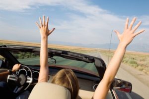 woman passenger in convertible with hands up2